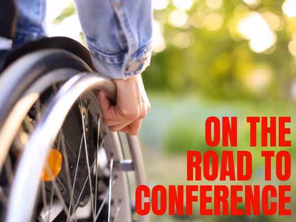 A wheelchair user moving forward. Caption: On The Road To Conference